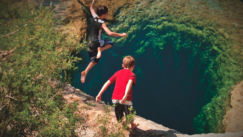Kids jumping into Jacob's Well